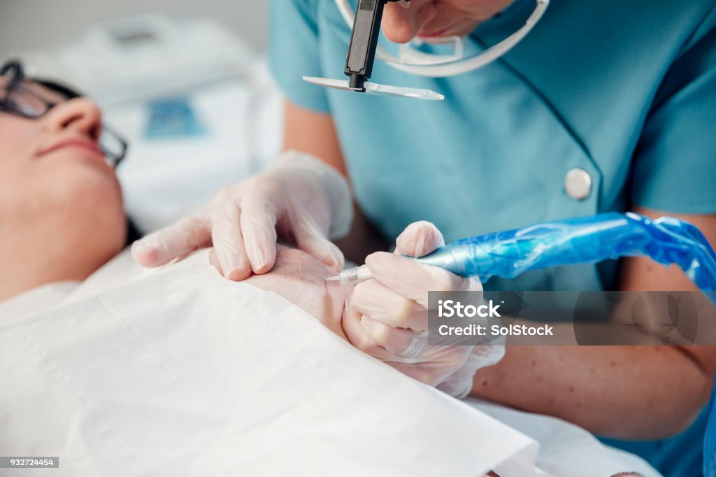A woman receives a medical tattoo on her breast.