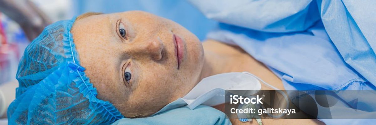 A woman lies in the operating room, ready for surgery. Surrounded by advanced medical equipment and healthcare professionals, she exhibits calmness and trust, highlighting the importance of the procedure.
